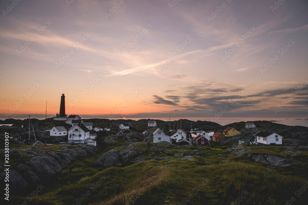 Island village with lighthouse at sunset