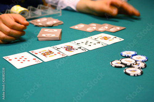 On the poker table there is a combination of cards, tokens, croupier hands, a stack for tokens.