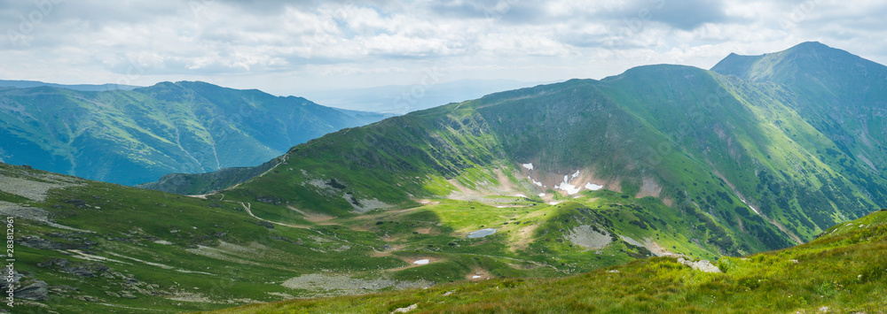 Panoramic view from Placlive peak on Western Tatra mountains or Rohace panorama. Sharp green mountains and lake rohacske pleso, ostry rohac, hruba kopa and volovec with hiking trail on ridge. Summer - obrazy, fototapety, plakaty 