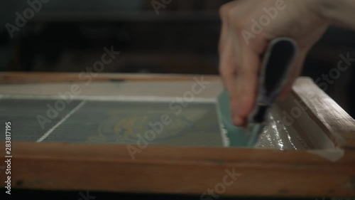 Man close up preparing t-shirt for printing in the silk screen printing machine. Only hands. Man preparing t-shirt for printing in the silk screen printing machine.