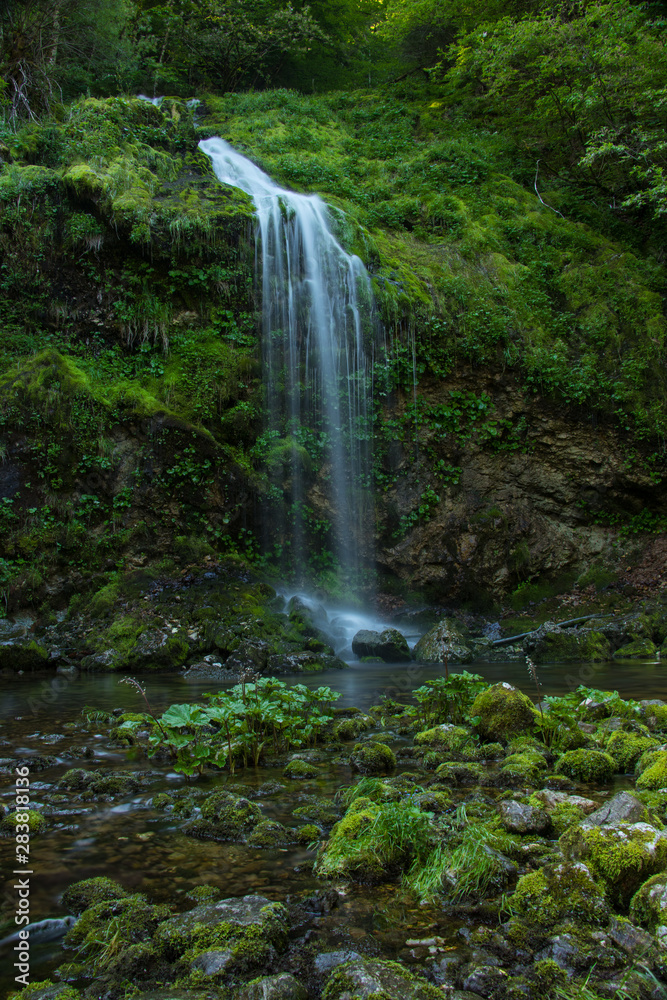 Obraz premium Beautiful green colorful small waterfall