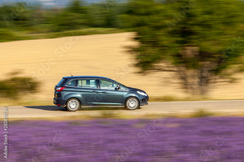 Motion blur image of the car which travells through countryside with lavender fields in Provence, France © Selitbul