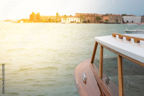 View from a wooden boat to the shore of Venice. with place for inscription and sun flare