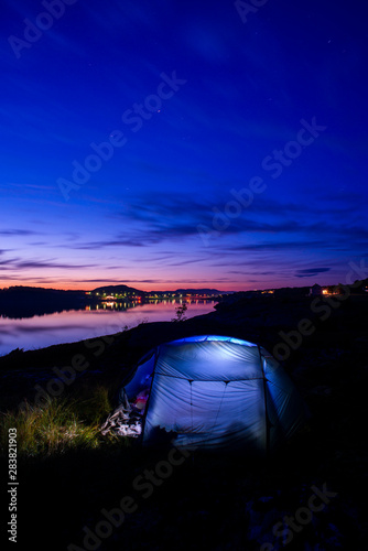 Camping with a tent in the sunset over a small village in Lysoysund in Norway