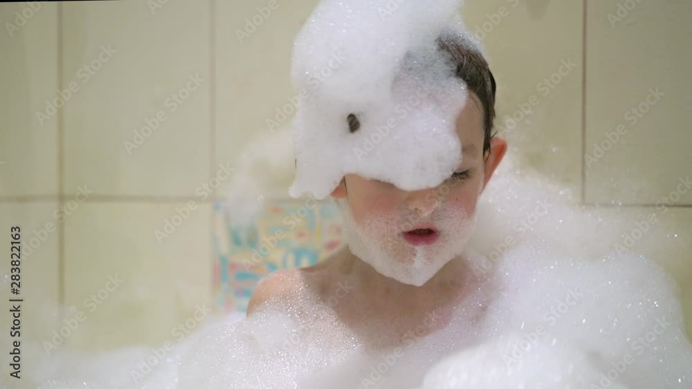 Boy taking a bath with bubbles