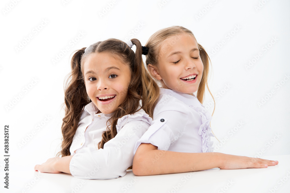 Happy childhood. Adorable schoolgirls. Back to school. Education concept. Beautiful girls best friends. Formal style. Schoolgirls sit at desk white background. Schoolgirls emotional friends Happy childhood. Adorable schoolgirls. Back to school. Education concept. Beautiful girls best friends. Formal style. Schoolgirls sit at desk white background. Schoolgirls emotional friends
