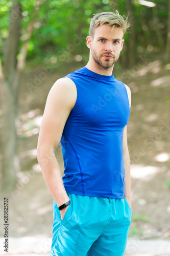 Youth sport. Handsome young sportsman enjoying sport activities on summer day. Athletic man in sport wear on natural landscape. Sport, fitness and leisure