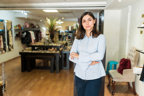 Pretty Female Salesperson With Arms Crossed In Shop