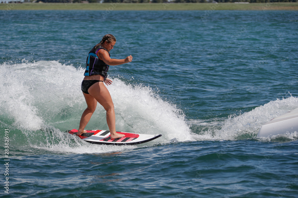 Woman surfing on a boat wake.