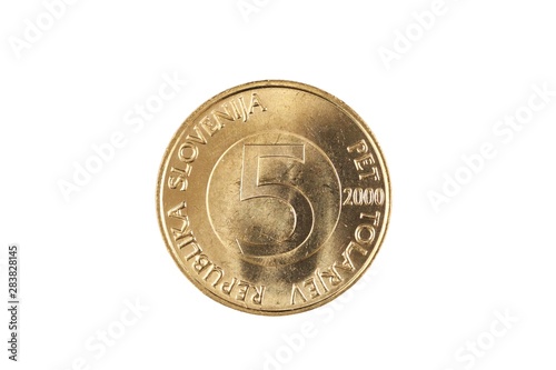 A gold, Slovenian five tolar coin, shot in close up macro, isolated on a white background