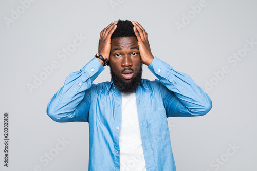 Fotografia Portrait unhappy upset guy, sad young african man bothered by mistakes hands on head eyes closed isolated on grey wall background