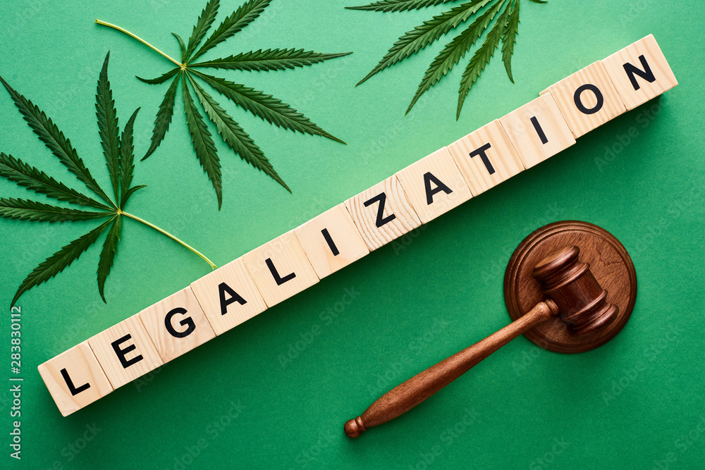 Αυτοκόλλητο top view of green cannabis leaves and legalization word on wooden blocks near ga