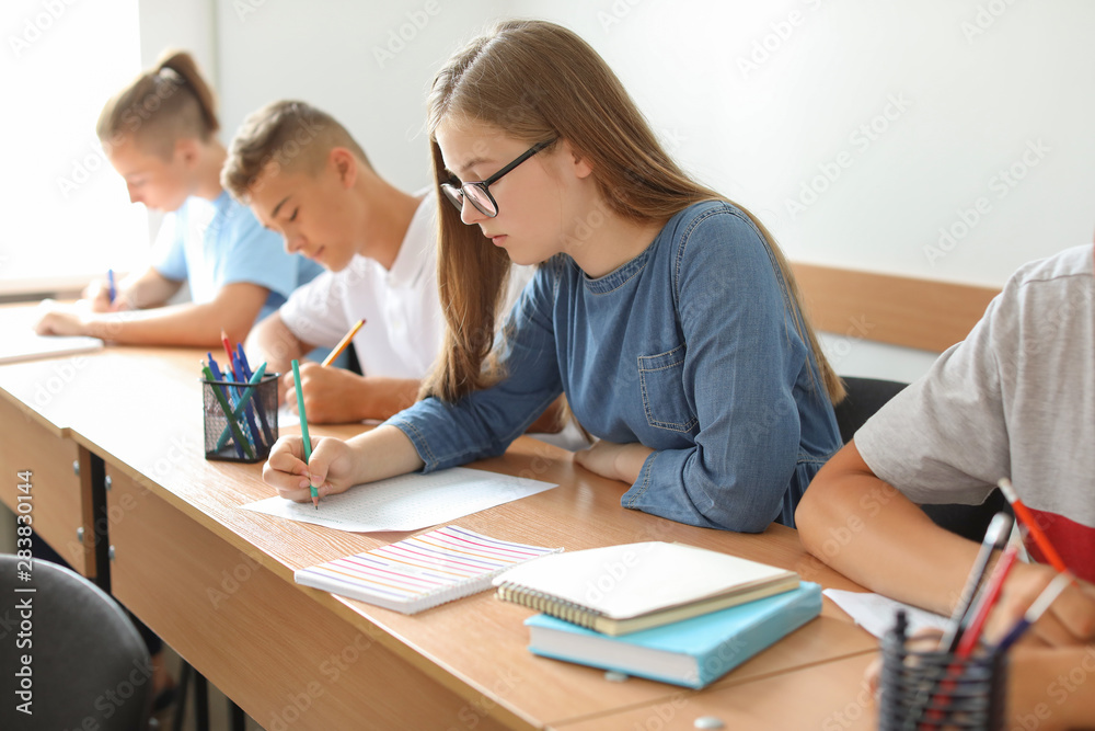 Pupils passing school test in classroom Pupils passing school test in classroom