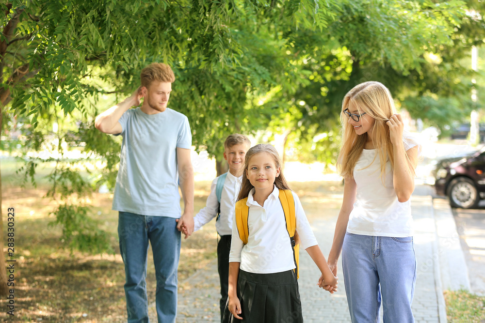 Fototapeta premium Little children going to school with their parents