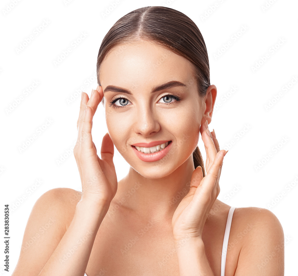 Beautiful woman massaging her face against white background