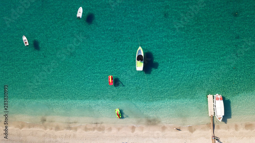 Aerial top view photo of sun beds and umbrellas in popular tropical paradise deep turquoise Mediterranean sandy crowded beach