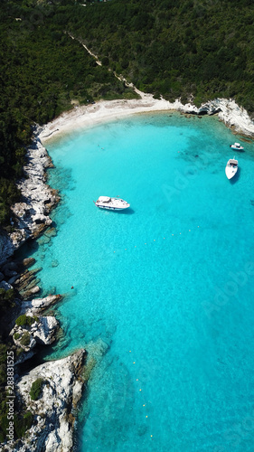 Aerial drone photo of tropical paradise turquoise beach of Voutoumi with sail boats docked in island of Anti paxos  Ionian  Greece