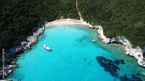Aerial drone photo of tropical paradise turquoise beach of Voutoumi with sail boats docked in island of Anti paxos, Ionian, Greece
