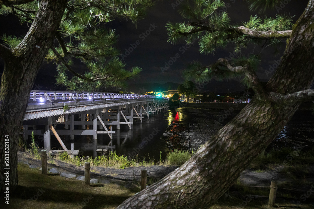 Night view of traditional wooden bridge leading to Arashiyama in Kyoto, Japan