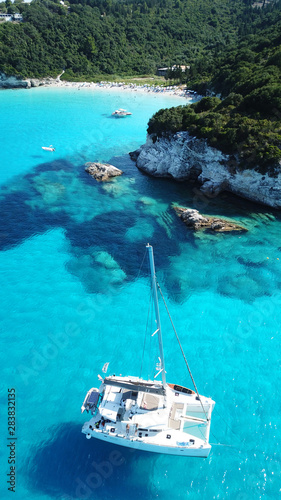Aerial drone photo of tropical paradise turquoise beach of Voutoumi with sail boats docked in island of Antipaxos, Ionian, Greece © aerial-drone