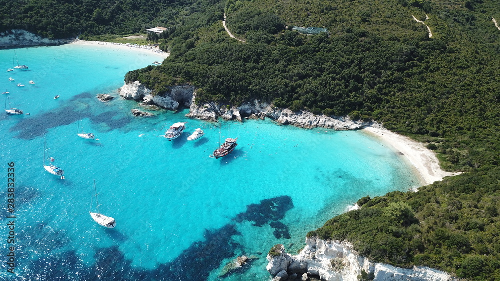 Aerial drone photo of tropical paradise turquoise beach of Voutoumi with sail boats docked in island of Antipaxos, Ionian, Greece