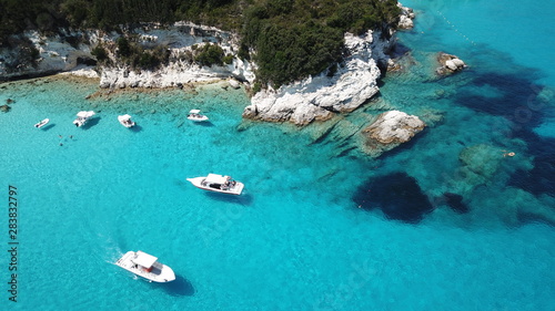 Aerial drone photo of tropical paradise turquoise beach of Voutoumi with sail boats docked in island of Antipaxos, Ionian, Greece