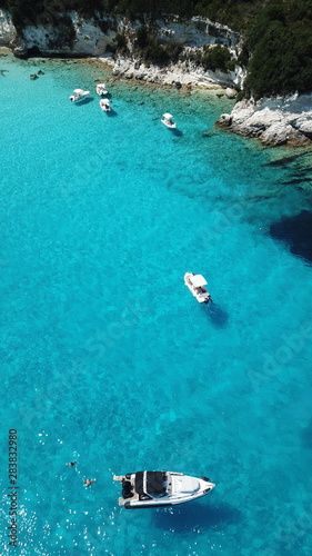 Aerial drone photo of beautiful exotic paradise turquoise sandy beach of Voutoumi with sail boats docked in island of Anti paxos, Ionian, Greece © aerial-drone