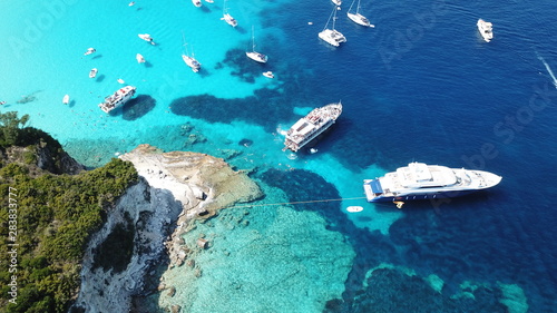 Aerial drone photo of beautiful exotic paradise turquoise sandy beach of Voutoumi with sail boats docked in island of Anti paxos, Ionian, Greece © aerial-drone