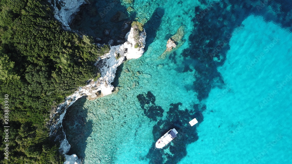 Aerial drone photo of beautiful exotic paradise turquoise sandy beach of Voutoumi with sail boats docked in island of Anti paxos, Ionian, Greece