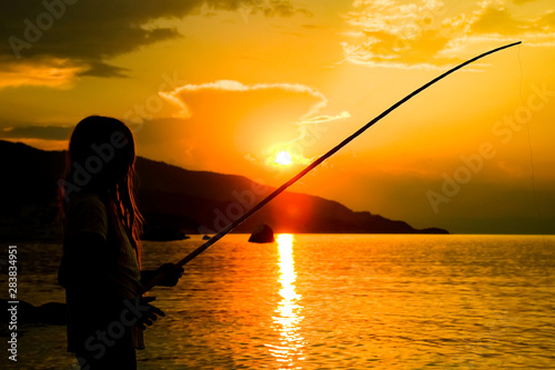 happy child fishing by the sea silhouette