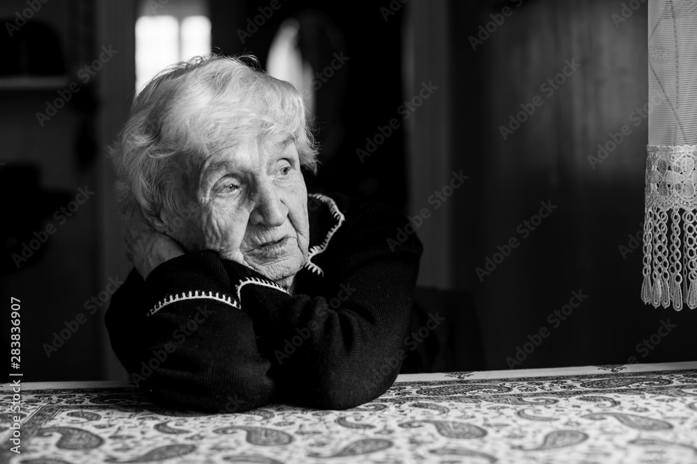 Lonely sad old woman. Black and white photo. - obrazy, fototapety, plakaty 
