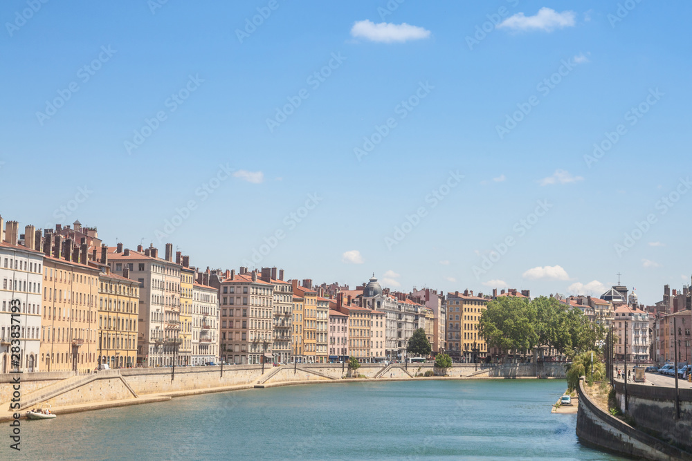 Panorama of Saone river and the Quais de Saone riverbank and riverside in the city center of Lyon, with a focus on the old building facades of the Presqu'Ile, also called Peninsula