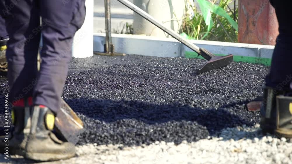 アスファルトの道路工事をする作業員 アスファルトの道路工事をする作業員