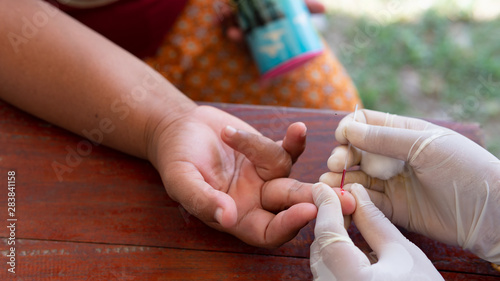 Medical worker or health worker keep blood, finger prick sample of Acetylcholinesterase activity in RBC or Plasma from farmer photo