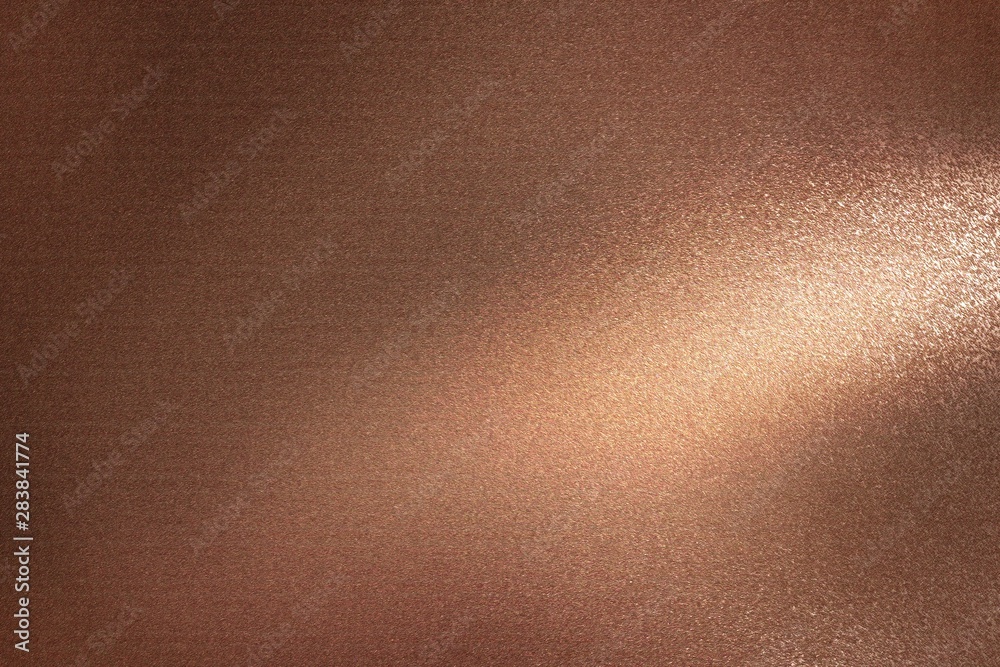 Glowing dark bronze metal wall with scratched surface, abstract texture background