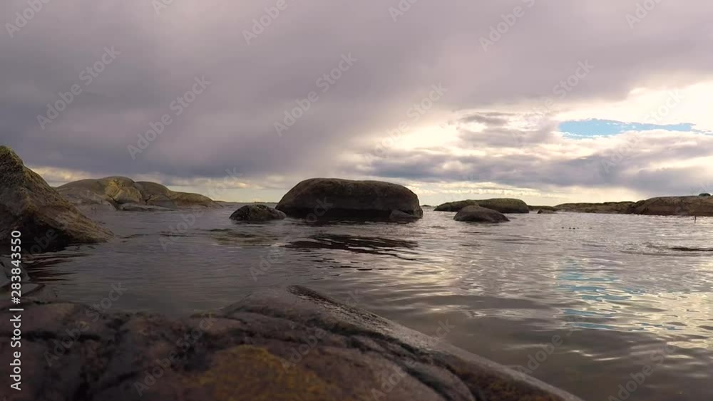 Calm peaceful sea waves hitting rocks in the island summertime in Sweden Calm peaceful sea waves hitting rocks in the island summertime in Sweden