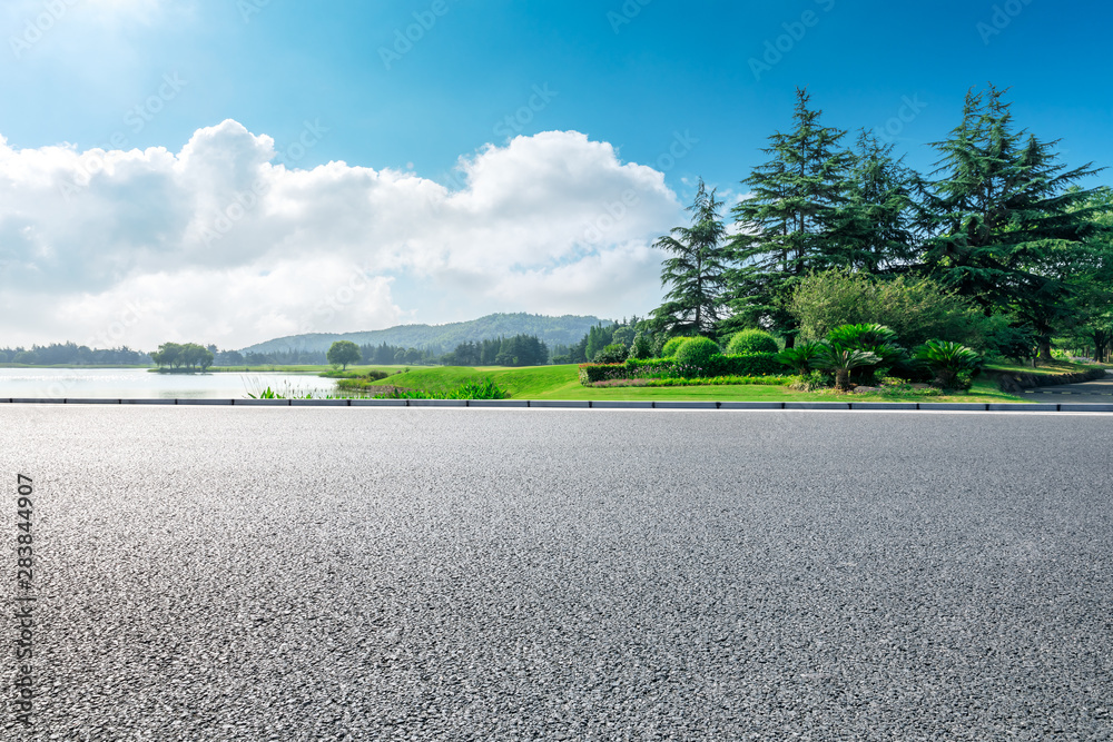 Country asphalt road and green woods with mountain nature landscape in summer