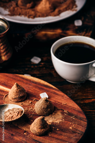 Homemade chocolate truffles coated in cocoa powder with black coffee