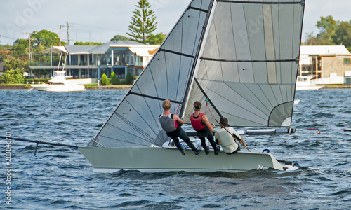 High school teens Sailing small sailboat with a Strong Wind on a lake. Lake Macquarie, Australia.