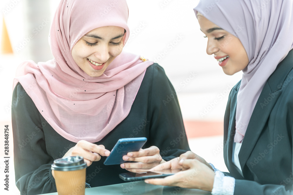 Muslim Businesswomen with their smartphone during their coffee break.