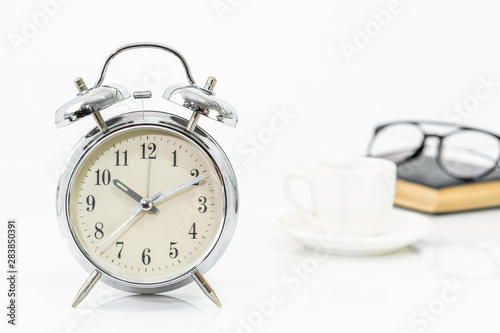 Silver alarm clock with old books