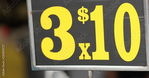 Yardsale sign or swapmeet indoors at chinatown displaying 3 for 10. Shot in slowmotion 4k.mov photo
