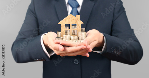 Coins stacked and house on each other in different positions, in hand photo