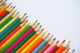 Various colored pencils on a white background for learning to draw in school laid out in a row diagonally.  With selective focus, copy spase for text.