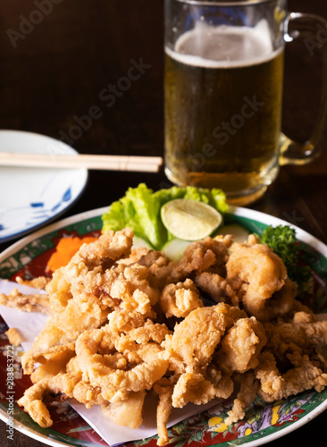 Japanese fried squid with cold beer on the table in the restaurant