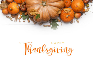 Thanksgiving Greetings. Pumpkins and dry leaves on a white background. Top view.