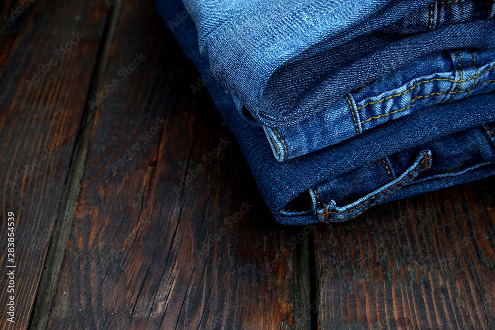 blue jeans on dark wooden background blue jeans on dark wooden background