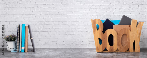 book shelf with books in wooden box on brick wall texture background.
