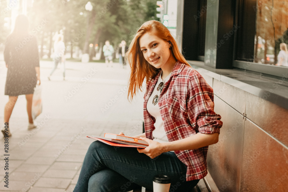 Obraz premium Attractive redhead smiling girl student dressed casual clothes at street in city