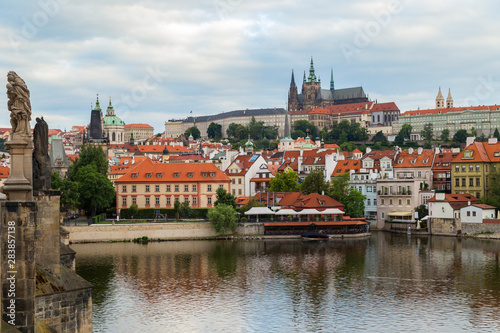 View of statues on the Charles Bridge (Karluv most), Mala Strana District (Lesser Town), Prague (Hradcany) Castle and St. Vitus Cathedral in Prague, Czech Republic, on a cloudy day. © tuomaslehtinen